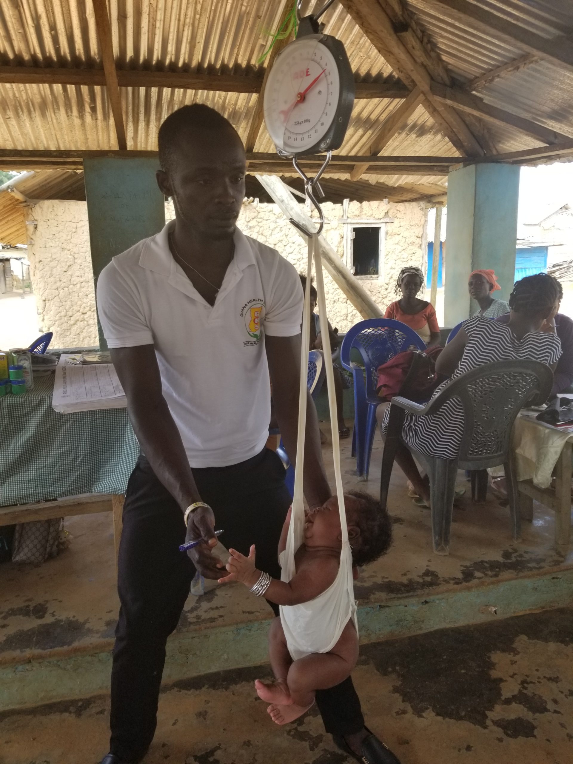 A health worker weighs a baby. Photo: Hen Mpoano.
