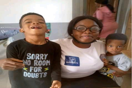 Two young boys are embraced by a Parkers Mobile Clinic worker