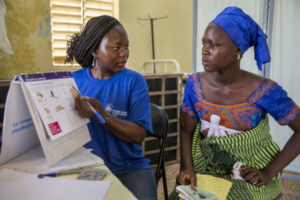 A team member from the mobile clinical outreach team at Marie Stopes International, a specialized sexual reproductive health and family planning organization on a site visit to Laniar health center, a rural area. She speaks to a woman, offering her sexual reproductive health services and counseling, including the full range of family planning options, emergency contraception, pre- and post natal care, and cervical cancer screening and treatment.