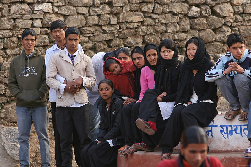 A group of students gather together in schoolyard.